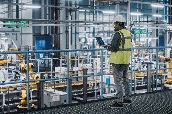 Car,Factory,Engineer,In,High,Visibility,Vest,Using,Laptop,Computer. Car,Factory,Engineer,In,High,Visibility,Vest,Using,Laptop,Computer.